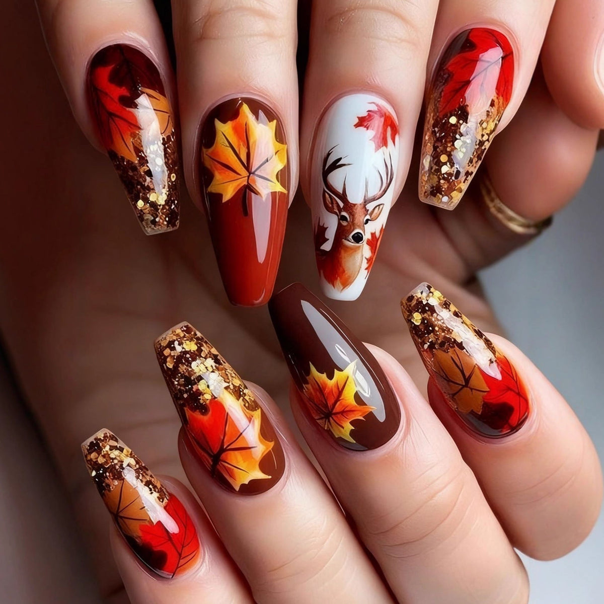 Nail art artificiale con design a foglie autunnali