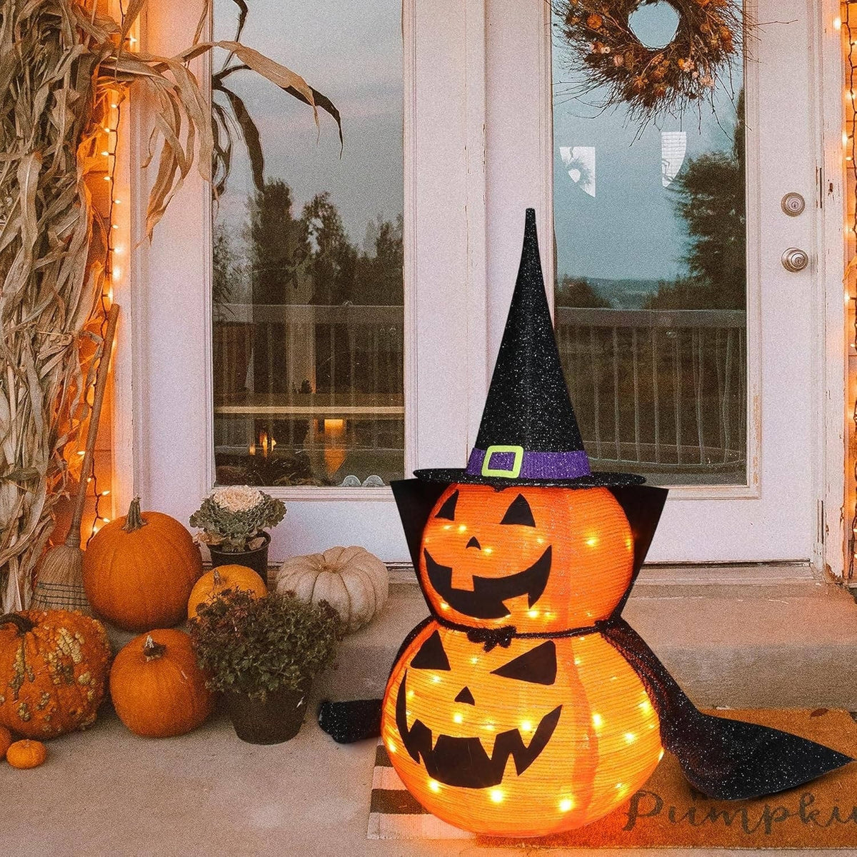 Decorazione di zucca di Halloween illuminata con cappello da strega e mantello per decorazioni natalizie all'aperto e al coperto